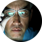 man with glasses looking at a computer screen