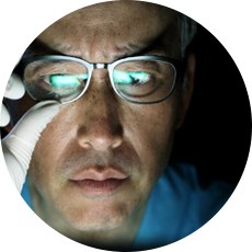 man with glasses looking at a computer screen